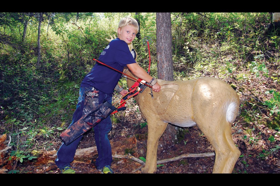 Nice shot: Joey Palagia of Canora retrieved his is arrow from one of the lifesize 3-D targets during the Assiniboinei River Archery Club's 23rd annual 3-D tournament. There were about 150 archers registered on Sunday. On the first day of the tournament, there were about 124 archers.