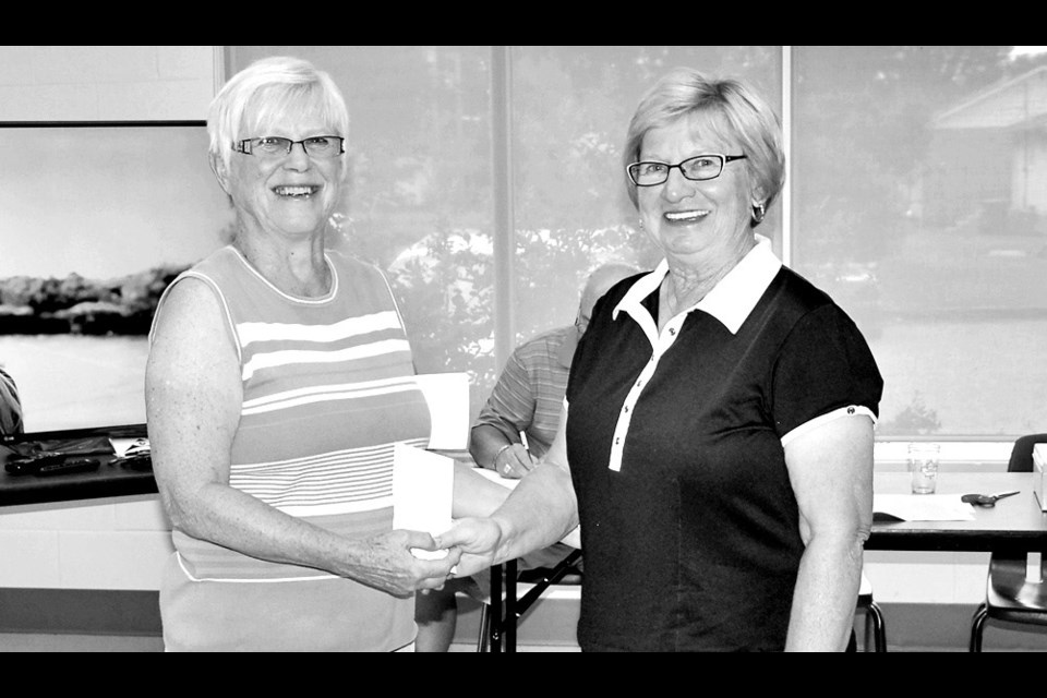 Phyllis Paul (right) of Preeceville shot a 92 to win the championship flite of the Canora women’s golf tournament on Saturday. Making the presentation was Maxine Stinka, a tournament organizer.