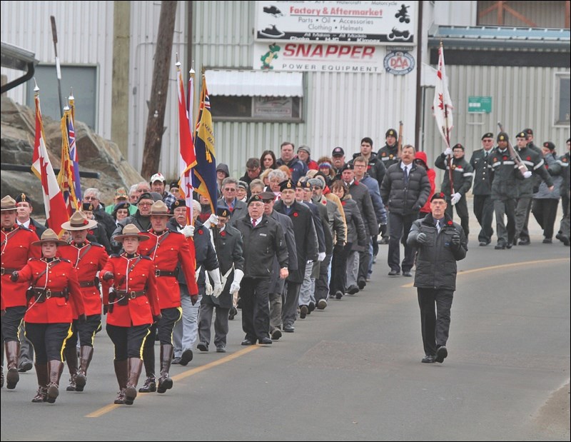 Marchers, with parade marshall Morley Naylor (right), make their way down First Avenue.