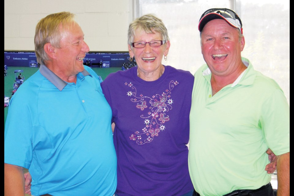 Glen Sterzer (left) and Daryl Binkley (right) of Kamsack won the men’s championship fl ite of the Canora Seniors’ Golf Tournament on Friday. Making the presentation was Eleanor Murray.