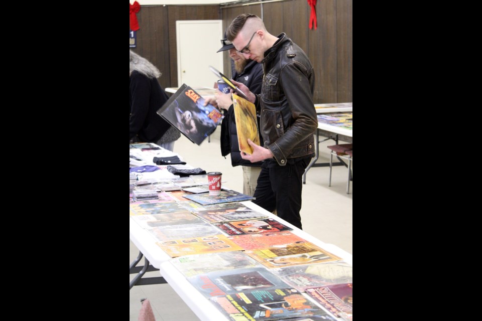 Music collectors peruse the selection of vinyl records for sale at the Melville Legion Hall Sunday during a Parkland Rock Radio fundraiser.