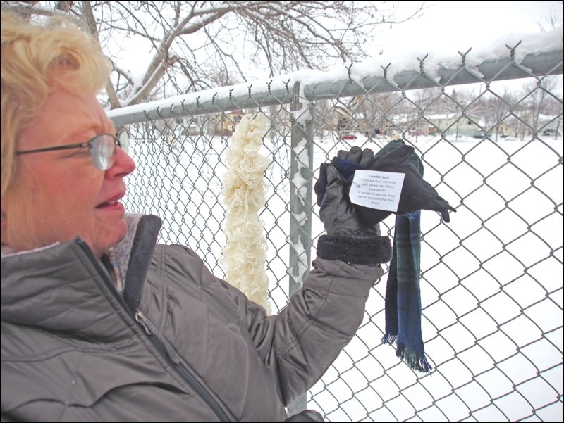 Carrie Hume shows a tag attached to each article of clothing distributed throughout the community. The tag explains that anyone who needs the article of winter wear can take it.