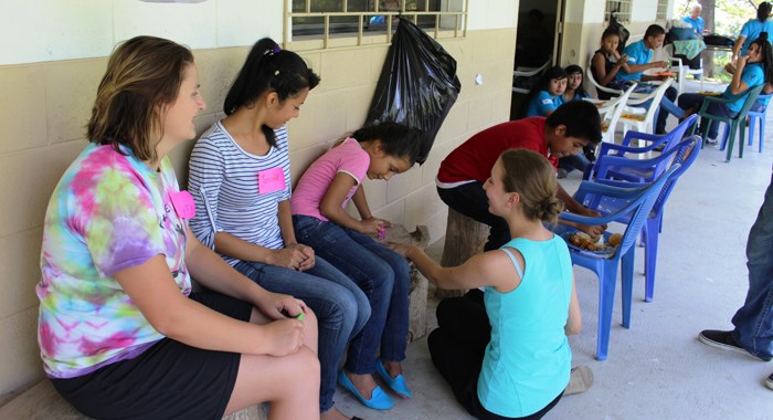 Kaitlyn Kitzan, left, working with school children in El Salvador.