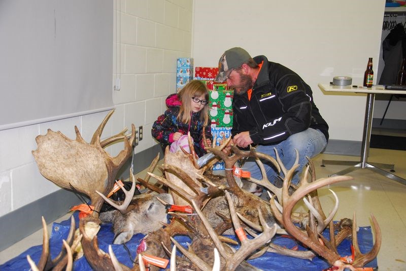 Sheldon Derkatch and his daughter Merrick had a close look at all the sets of antlers brought in December 8 during the official measuring day of the River Ridge SWF branch.