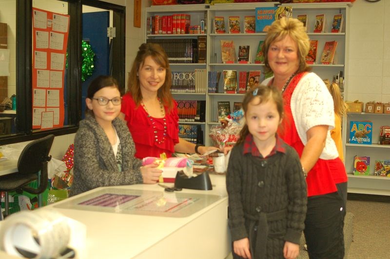 Santa helpers Santa had some special helpers at the Children’s Christmas store at the Preeceville School on December 9. From left, were: Shanae Shewchuk, Lanette Englot, Linda Shewchuk and Dexter Pennerw who had some gifts wrapped by the helpers.