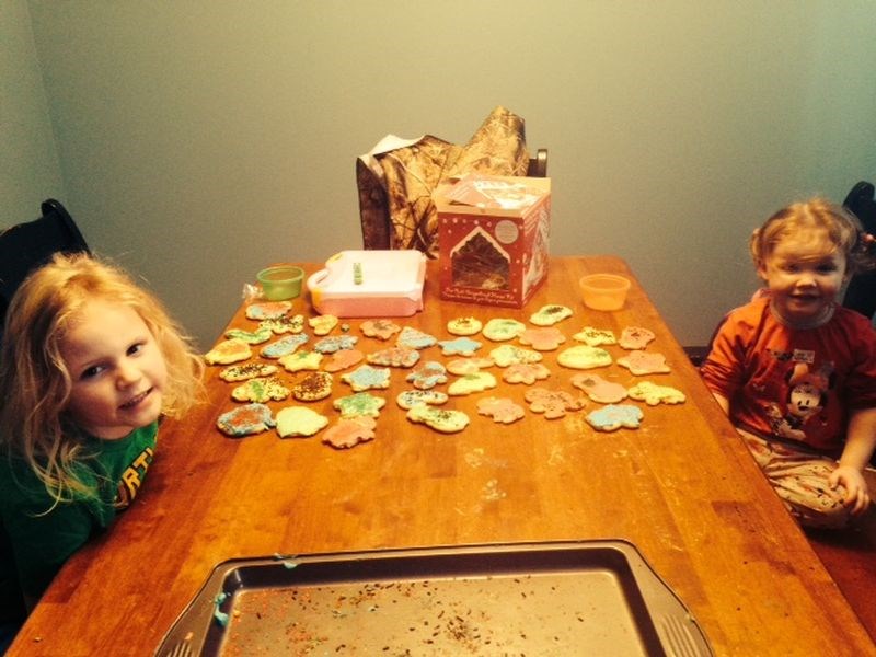 Admiring the results of their hard work in making and decorating sugar cookies with their mother, Becky Scheller, in Ketchen were Abby and Allie Scheller.