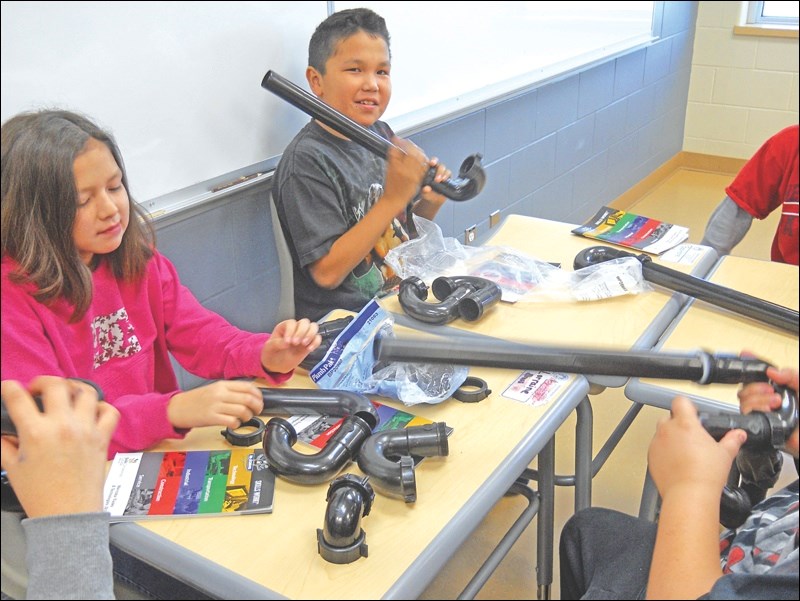 Moose Lake students Baptiste Buck and Lorraine Brass learn about plumbing at a station run by Skills Manitoba North during the Introduction to Vocational Learning pilot in Moose Lake in late 2015.
