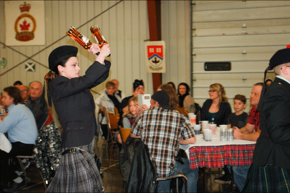 Jamie Guertin with the celebrated bottles of scotch that were piped into the Robbie Burns celebration on Saturday night along with the haggis.