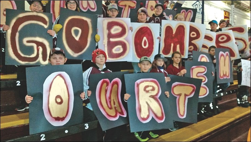 Young fans held up letters spelling out GO BOMBERS and OUR TEAM at the Hockey Night in the North game.