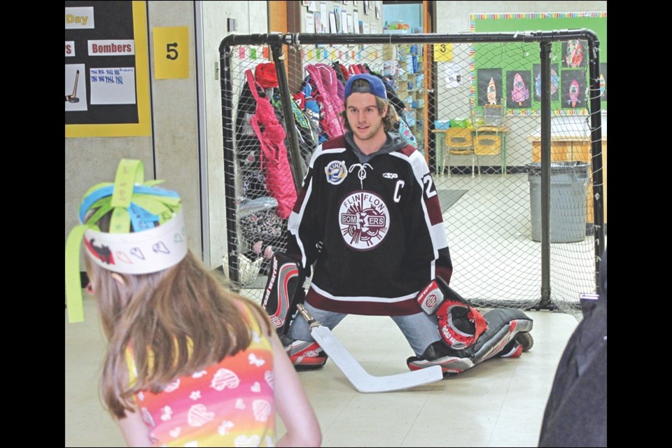 Flin Flon Bombers captain Tyson Empey, a forward, took a turn in the net to try and stop a shot from an École McIsaac School student at celebrations marking the 100th day of school.