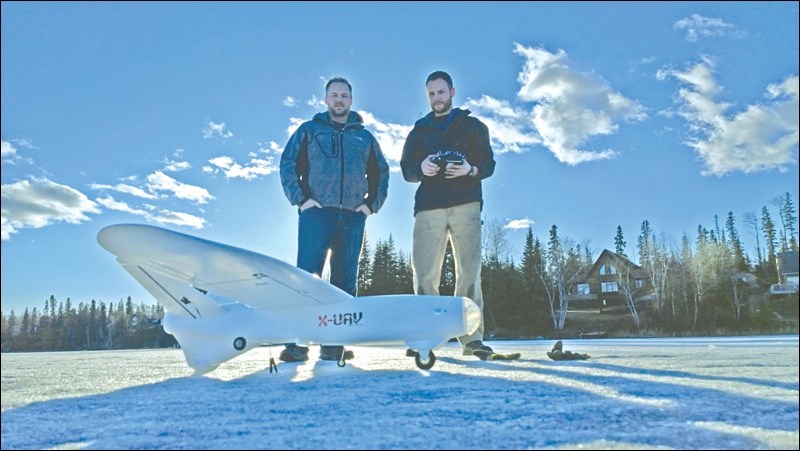 AIR co-owner Peter Dueck (left) and mechanic Nathan Willems prepare a drone for takeoff.