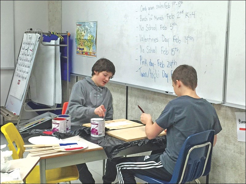 Morgan Daneliuk and Kaydon Jess, Grade 7 students at Ruth Betts, build miniature hockey rinks as part of the design group in the enrichment program.