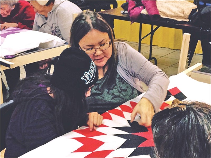 Virginia Gardiner instructs a local youth on the quilting process. Young people joined in on two sessions of the elders sewing circle at the Friendship Centre.