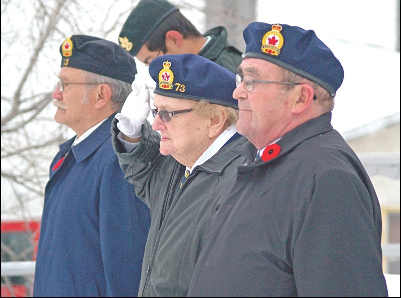 Marg Beever stands at the Cenotaph as participants in Flin Flon’s 2010 Remembrance Day parade march by.