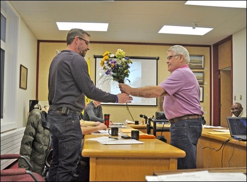Battleford town councillor Ames Leslie receives a bouquet from weed man Dave Whitehead who has hidden a noxious surprise among the blooms – leafy spurge. It can show up in a flower garden and spread unless residents know how to recognize the plant.