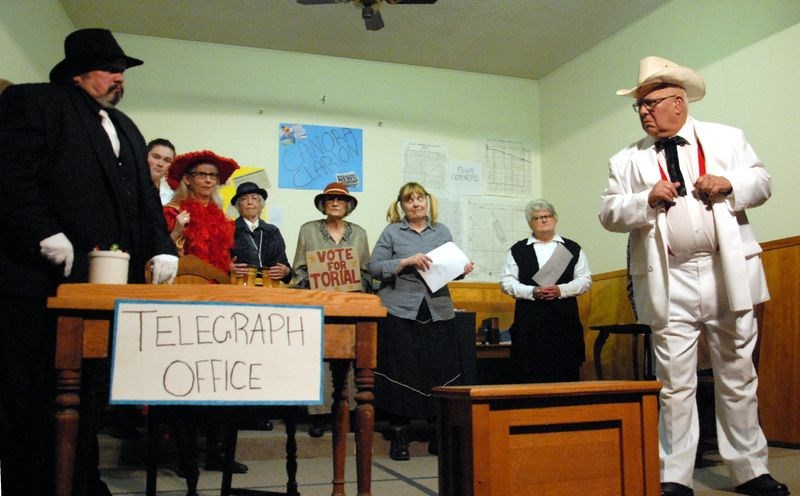 Sleazy Tab Lloyd (left), who is the villain played by Brett Watson, met his opponent, Edward Torial (played by Thom Carnahan) in the election for mayor at the newspaper office. In the background, from left, are a few of the town’s citizens: (played by) Kelsey Chupa, Marg Janick Grayston, Joy Stusek, Dianne Manahan, Darcey Lemaire and Karen Wishlow.