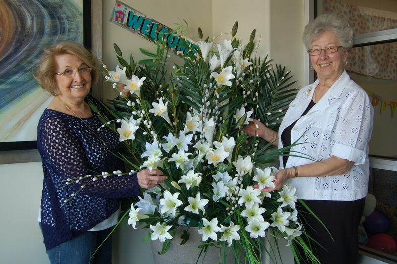 Now that Don Hollett is the property manager at the Assiniboine Valley Estates, his wife Milena, who is well known in the community for her floral arrangements, keeps the entrance to the building decorated according to the season. After removing her St. Patrick’s Day displays, Milena developed an Easter-themed display which includes a large arrangement of white lilies. Photographed with the display on Friday were Marie Broda, left, and Bernice Makowsky, who are tenants at the building.