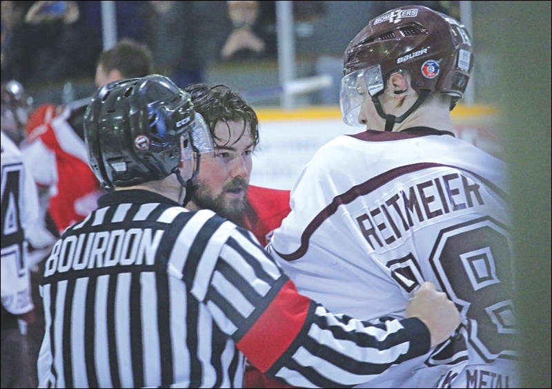 Referee Jason Bourdon attempts to break up a skirmish between Bombers forward Greyson Reitmeier and a Red Wings player. A melee broke out after a Weyburn player tried to steal a celebratory moose leg.
