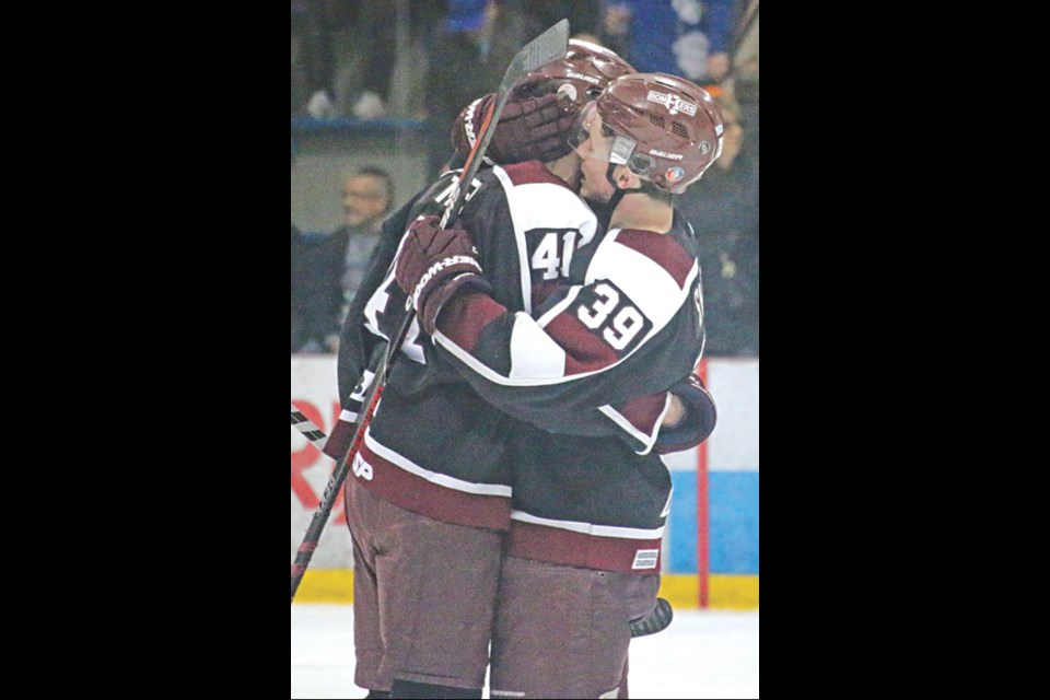 Bombers forward Rylee Zimmer (left) hugs teammate Brandon Switzer after scoring in double-overtime in North Battleford last Saturday, April 9. The goal eliminated the North Stars and sent Flin Flon to the SJHL final for the first time since 1993.