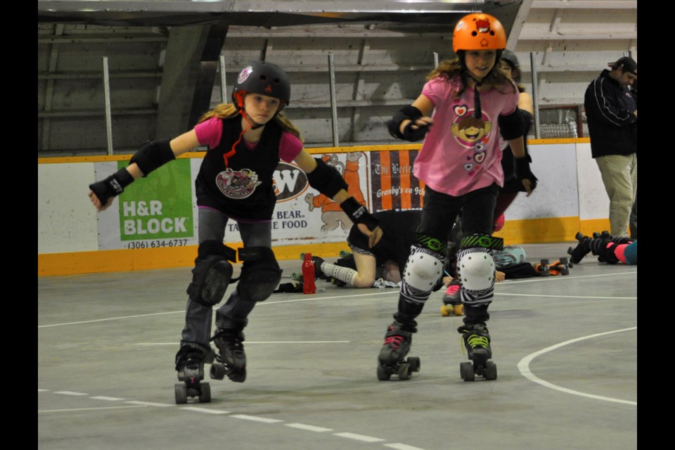 Sprite Fright, left, and Cat Strike race around the roller derby track during the Coaler Rollers' Skate-a-thon.