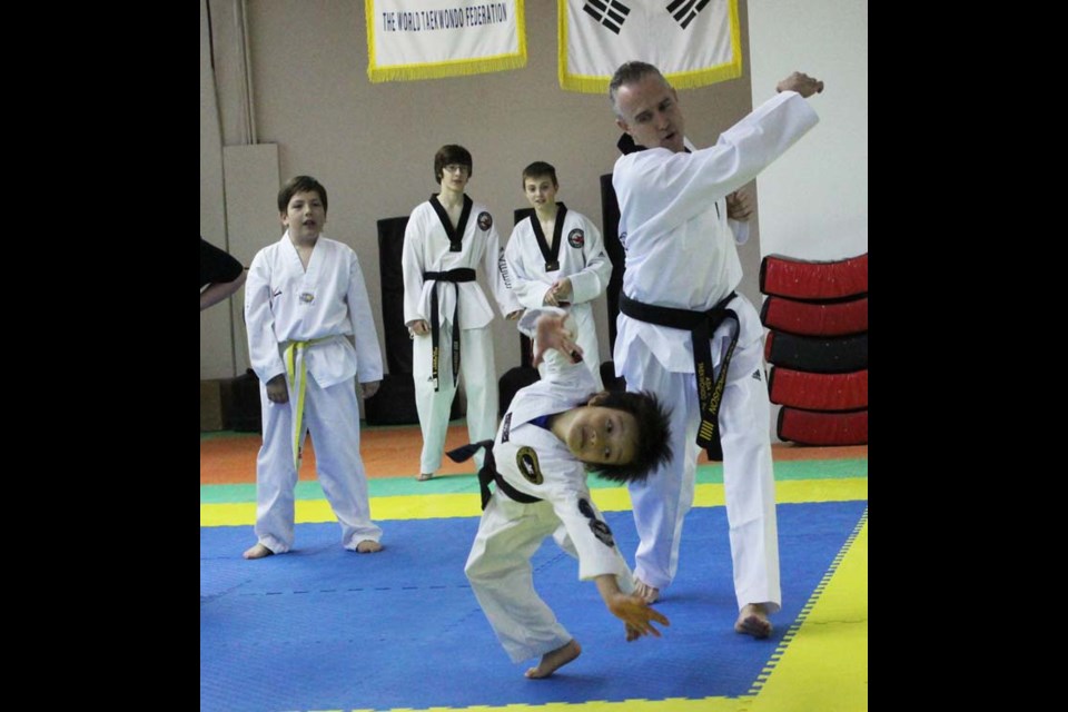 Don Ferguson and his son Ronnie (flipping) show students at Kees Tae Kwon Do how to punch and ‘sell’ for a movie shoot.