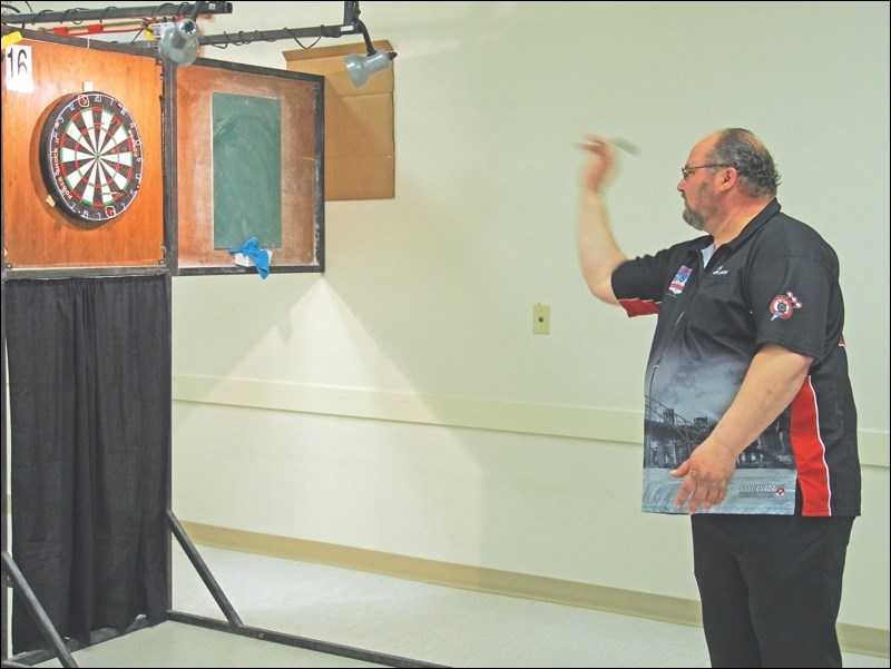Dean Corlett lets a dart fly during the Flin Flon Open Darts Championships last weekend. Corlett was on the winning teams for both the doubles and triples finals, but lost the singles competition to his doubles partner, Ron Looker.