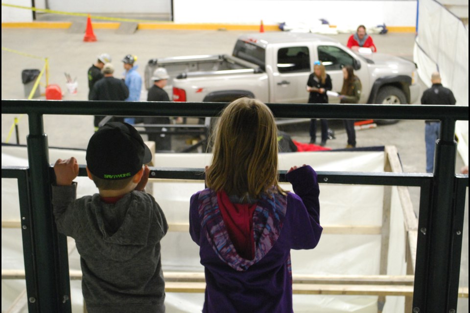 Children look on as their fathers compete in the Lanigan In Plant Competition
