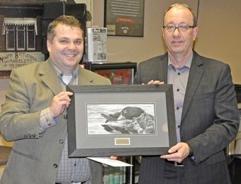 Mike Nord makes a presentation to outgoing Discovery Co-op board president Randy Graham as he steps down to take over a role on the board of Federated Cooperatives Ltd. Photos by John Cairns