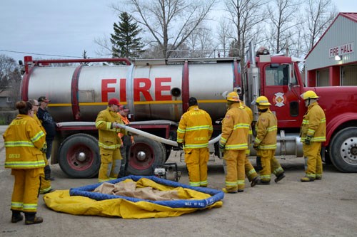 Carlyle Fire & Rescue's recent practice focused on fighting grass fires. Here, members ready a portable drafting pool, so it can be filled up with water from the department's tanker truck. “The pool is an extra source of water when we're fighting fires in rural areas,” says Deputy Chief John Brownlee. “We empty the water from the tanker into the pool and then head back to town for more water if we need it. The pool holds just over 7,000 litres of water and depending on the pressure and the size of the nozzle we use, we can use up to 1,000 liters of water per minute.”