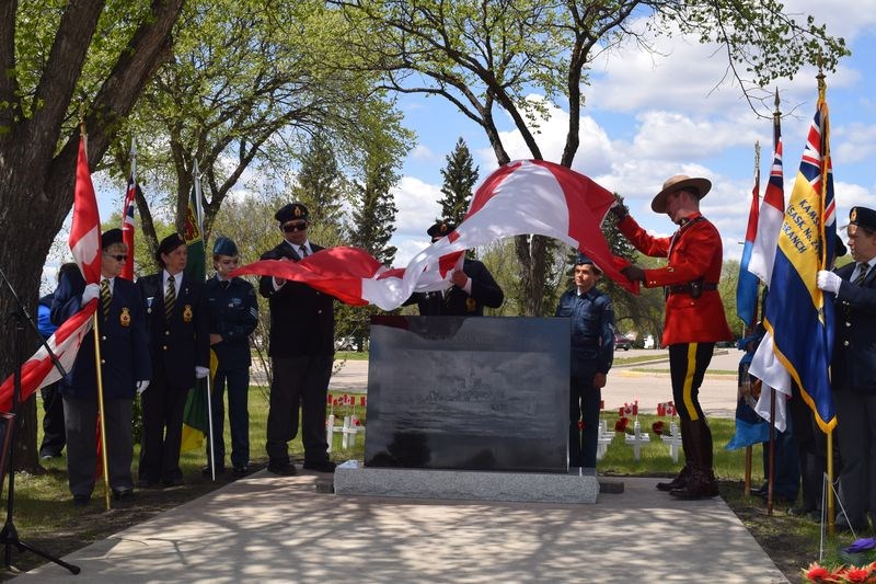Legion members and members of the RCMP removed a Canadian flag from the monument to unveil it to the public.