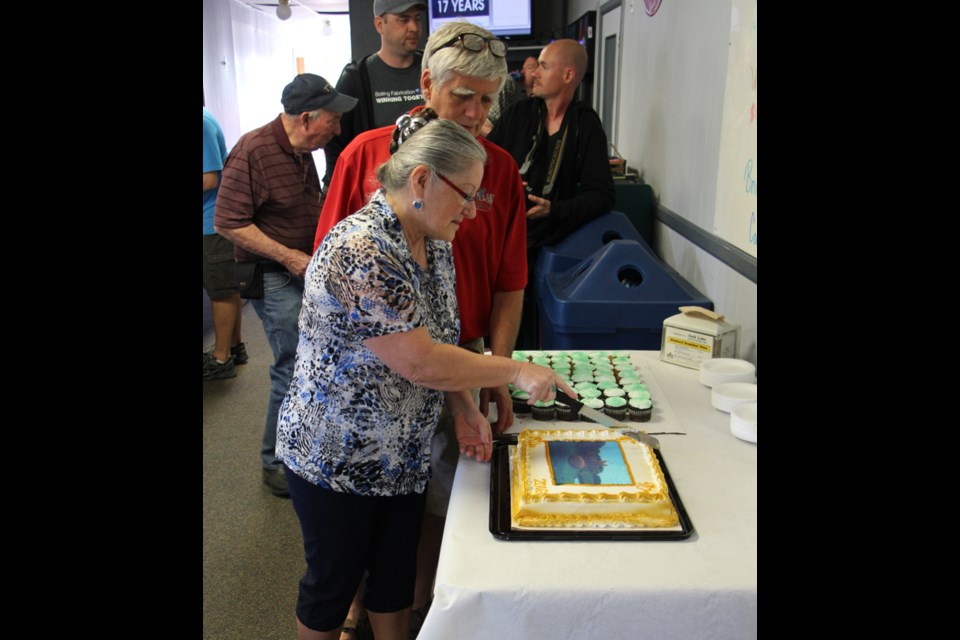 Cutting the cake at the 90th Anniversary of York Lake Golf and Country Club are Judy Hughes, club president, and Tom Seeley.