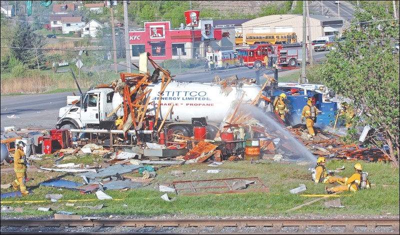 Firefighters at the scene of Wednesday morning’s explosion, which obliterated the mechanical shop at the south end of the Stittco Energy Ltd. property on Third Avenue.