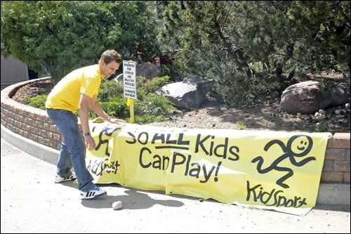 Co-Chair of KidSport, David Schell, gets the banner ready for the barbecue. The event took place from 10 a.m. to 2 p.m. Friday.