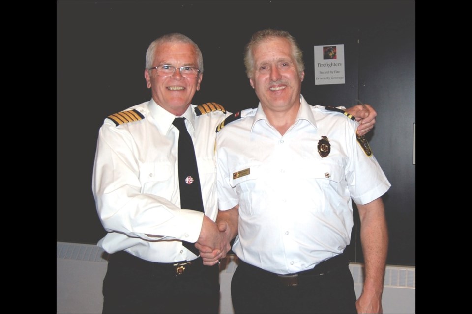 Firefighter David Andres (right) with now-retired fire chief Jim Petrie. Andres accepted a 20-year service medal.