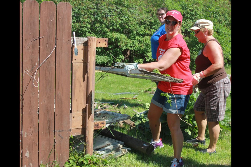 Day of Caring committee member Roberta DeRosier helped clean up a shed at a residence on Duncan Road.