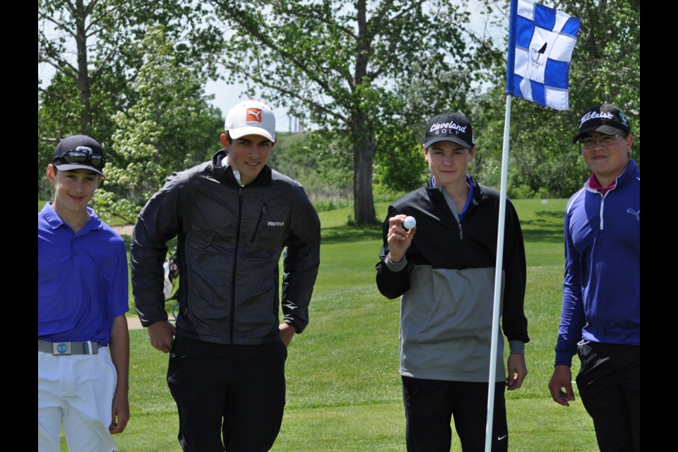 Reegan Robinson shows off the ball he hit for a hole-in-one on the 17th hole while playing with golfing partners, from left, Jayden Dudas, Kane Altwasser and Jace Carlisle.