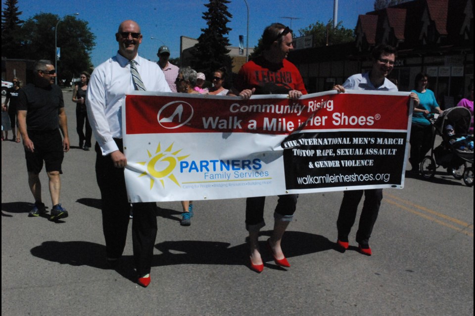 Randy MacLean, Andy Burgess, and Colby McClelland lead the march to stop rape, sexual assault, and gender violence during the Walk a Mile in Her Shoes walk in Humboldt on Jun. 9.