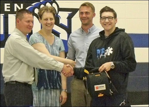 The Metanchuk family — Dean Broughton, Donna Metanchuk and Mitch Luiten and Myron Metanchuk — donating an AED to Borden School.