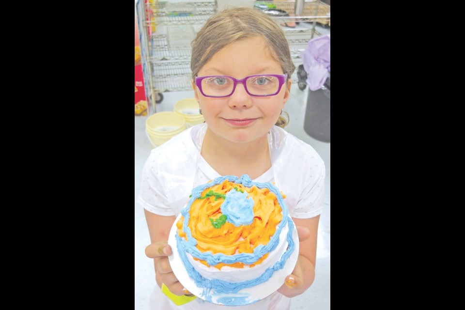 Lacey Svaren shows off an icing-rich cake she decorated for her dad.