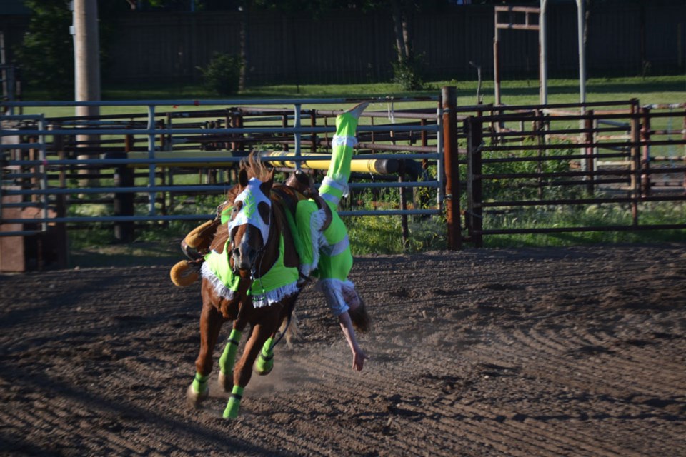 Carlee Ross performs one of many daring maneuvers on horseback, on June 20, at the Estevan Rodeo Grounds.