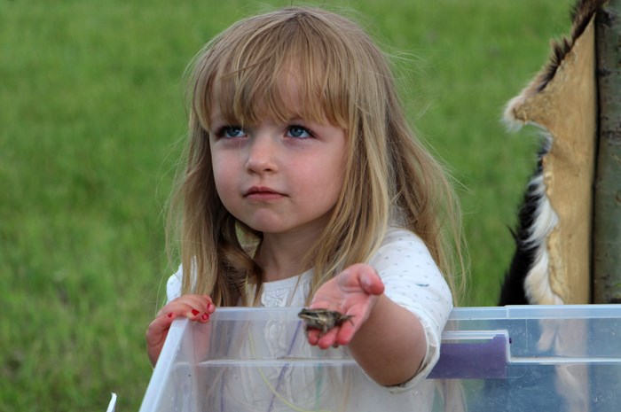 Shay Randall shows off a frog at the Yellowhead Flyway Birding Trail Association booth, where people could learn about some of the wildlife in the area.