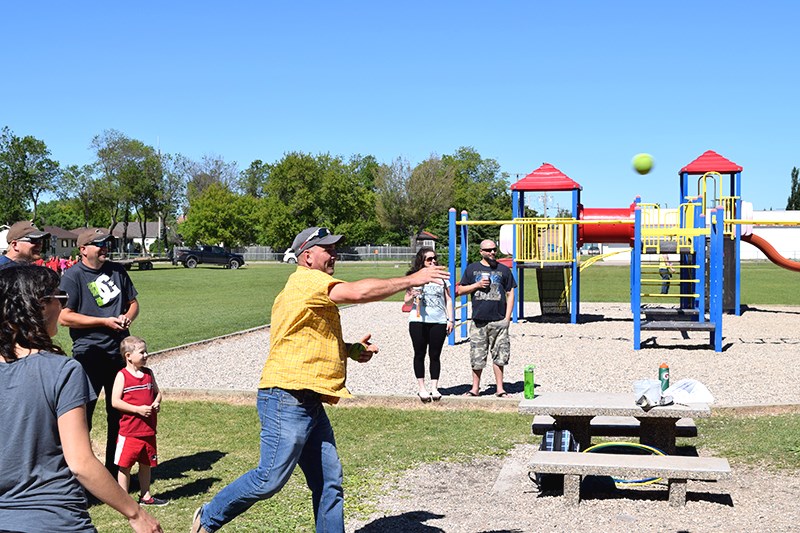 A visitor to the event tosses a ball that managed to dunk Cal Homeniuk into the tank.