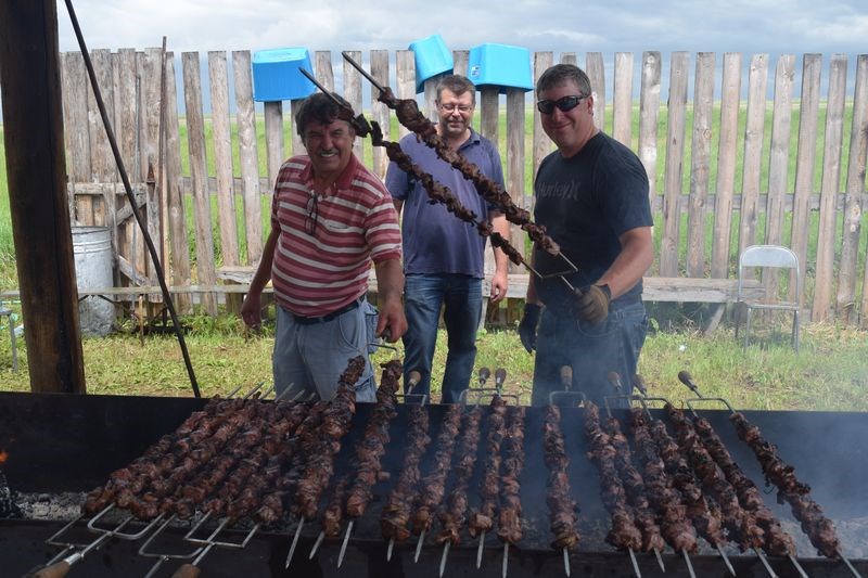 At work at the barbecue pit during the 72nd annual Veregin shishliki barbecue and beer gardens held at Veregin on Saturday, from left, were: Leo Lucash, Jon Bloudoff and Aaron Chernoff. A total of 1,500 pounds of lamb was prepared, cooked and served at the event.