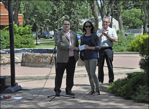Mike Nord, manager of Discovery Co-op, presents North Battleford Business Improvement District Executive Director Lisa Kissick with a cheque for $89,000 for Central Park rehabilitation while Mayor Ian Hamilton looks on. In the background is the unused fountain that will be removed. Photos by Jayne Foster