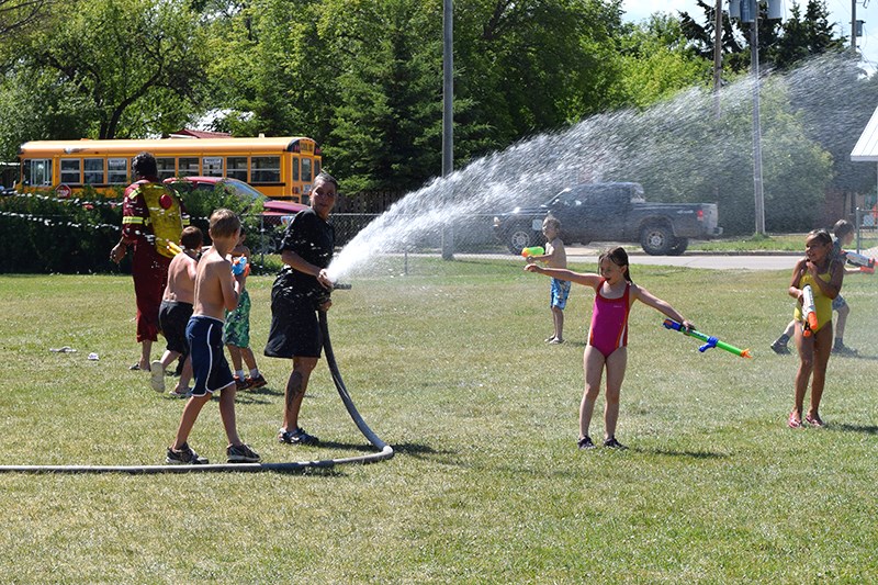 Some students cooled off in the spray from the water hose.