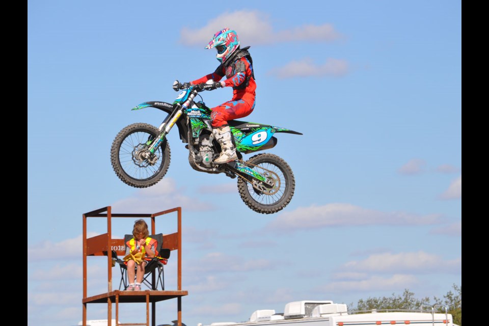 Kate Lees flies past a race checker during the Womens' class feature at Trackside MX Park on Saturday.