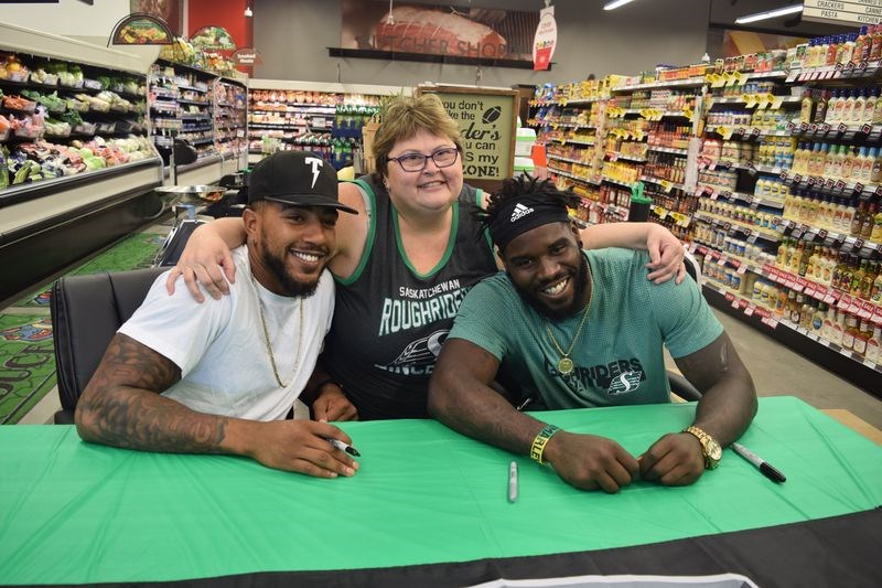 Cindy McGregor of Kamsack was among the lucky residents who were able to greet Saskatchewan Roughriders Jonathan Newsome, left, and AC Leonard on Sunday when they were at the Kamsack Co-op grocery store as part of the Co-op Game Day Approved campaign.