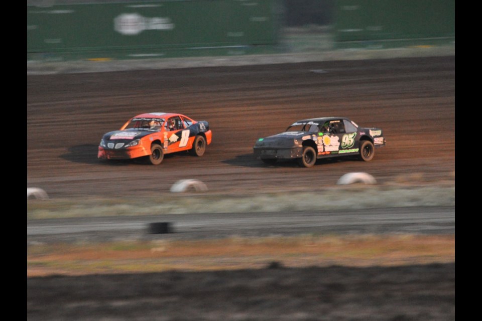 Robert Pickering, #8, leads Gregg Mann on the third corner during the stock cars heat race.