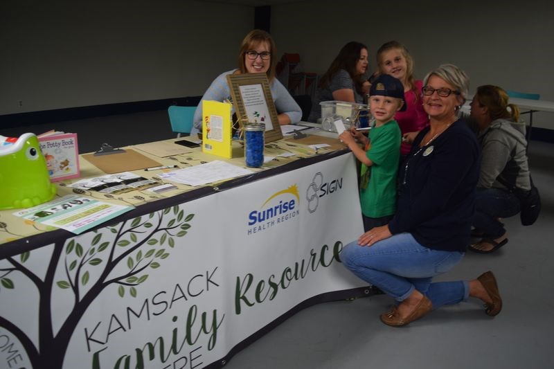 Megan Peters, left, and Andrea Verigin discussed a program offered by the Kamsack Family Resource Centre with Nate and Grace Shabatoski during the annual fall registration night last week.