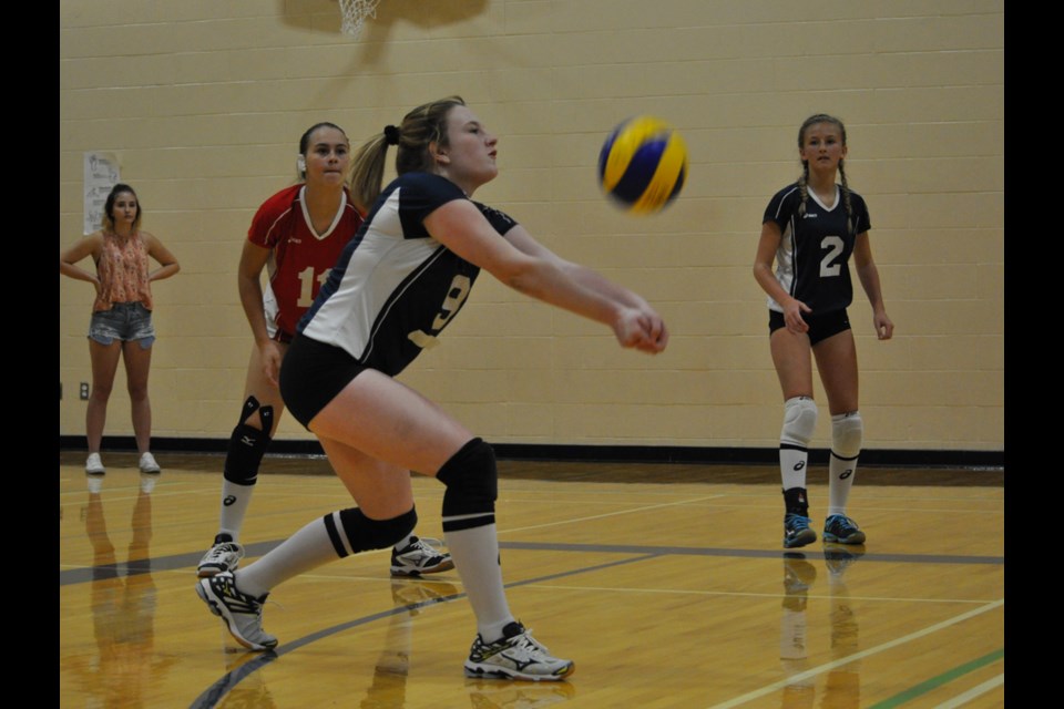 Elecs' Bailee Mickel returns a shot against the Eagles at the ECS junior girls volleyball tournament on Saturday while Shanelle Rioux, #11, and Abby Hanson look on.